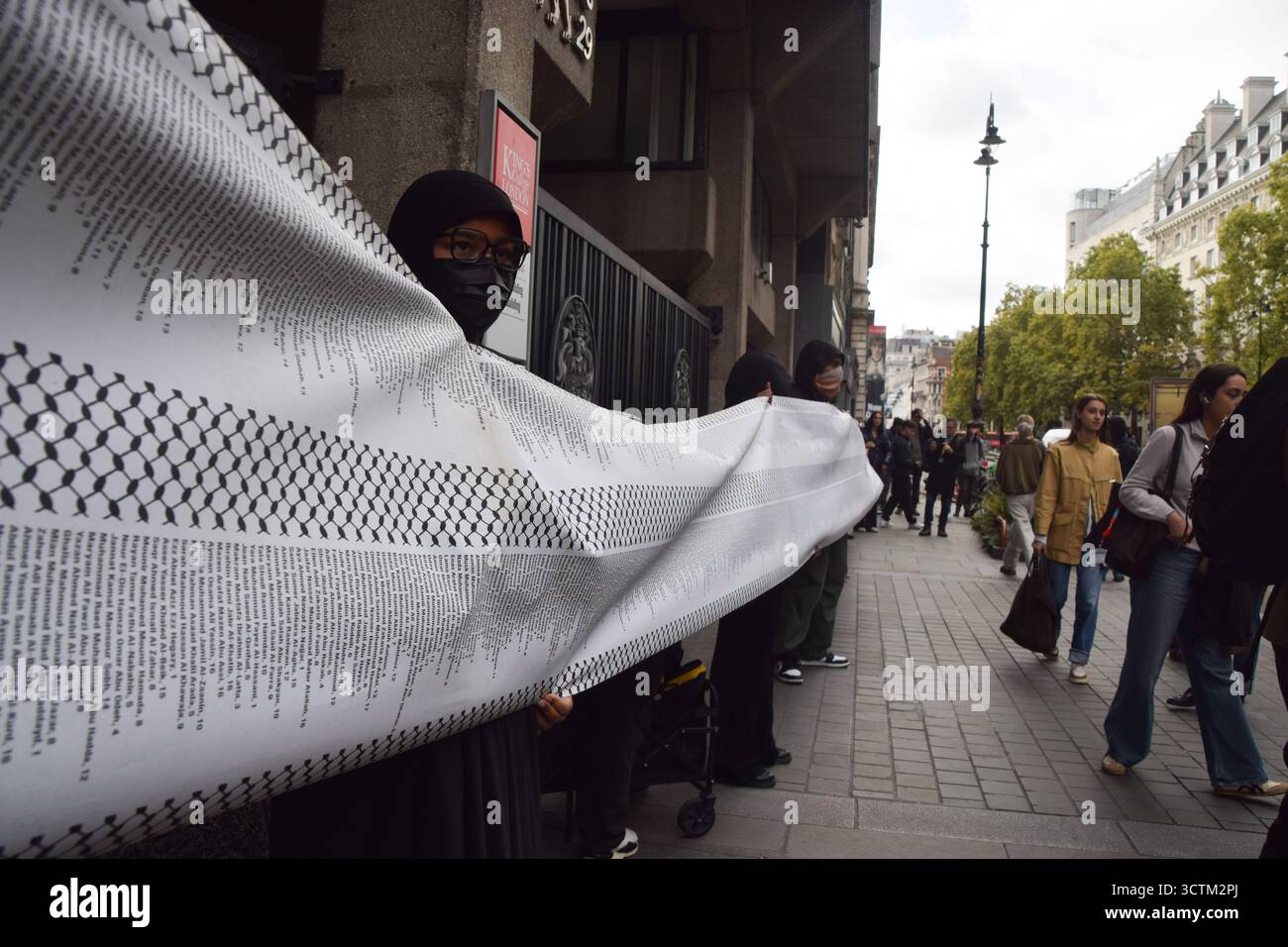 Londra, Regno Unito. 7 ottobre 2025. I manifestanti pro-palestinesi al di fuori del King's College di Londra tengono una lunga lista di nomi di bambini uccisi da Israele a Gaza in occasione del secondo anniversario dell'attacco di Hamas al Nova Festival in Israele e dei successivi attacchi a Gaza da parte di Israele. Gli studenti marciarono dal King's College e si fermarono in vari campus lungo la strada, chiedendo la fine del genocidio a Gaza. Crediti: Vuk Valcic/Alamy Live News Foto Stock