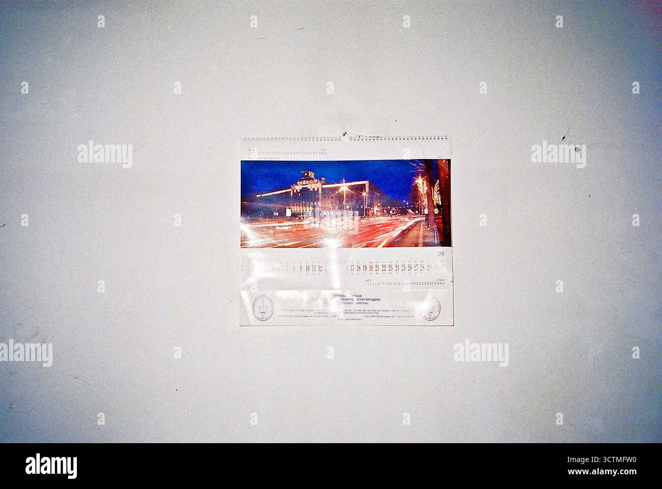 Un vecchio calendario su un muro bianco all'interno di una fabbrica abbandonata. Ripresa su pellicola analogica con flash. Foto Stock