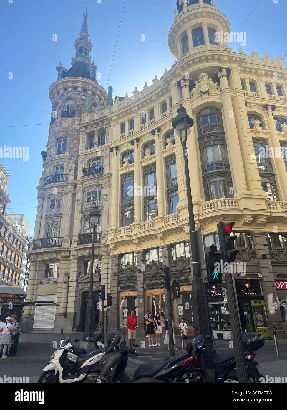 Elegante edificio storico nel centro di Madrid, in Spagna, con architettura ornata e facciata ad angolo arrotondato in una soleggiata giornata estiva. - Immagine stock catturata con smartphone