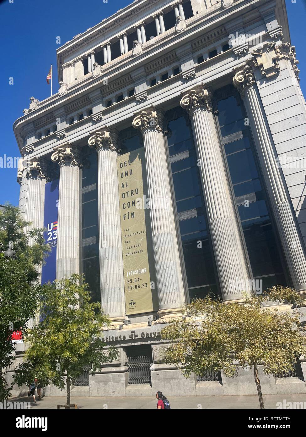 Vista laterale dell'edificio de las Cariátides a Madrid, Spagna, storico edificio neoclassico con facciata ornata sotto un luminoso cielo estivo. - Immagine stock catturata con smartphone