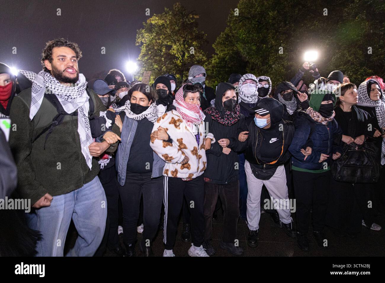 Centinaia di manifestanti filo-palestinesi si sono riuniti nei pressi della Fontana di Nettuno presso Alexanderplatz nel centro di Berlino martedì 7 ottobre 2025, nonostante il divieto della polizia alla manifestazione, in occasione del secondo anniversario degli attacchi terroristici di Hamas contro Israele. I partecipanti hanno cantato slogan come "Gloria alla resistenza", "Intifada fino alla vittoria" e "dal fiume al mare, la Palestina sarà libera”. Gli scontri scoppiarono quando gli ufficiali si trasferirono per disperdere il raduno, portando a numerosi arresti e scontri. La scena è diventata tesa e caotica mentre i manifestanti resistevano agli ordini della polizia. Il momento del rally o Foto Stock Centinaia di manifestanti filo-palestinesi si sono riuniti nei pressi della Fontana di Nettuno presso Alexanderplatz nel centro di Berlino martedì 7 ottobre 2025, nonostante il divieto della polizia alla manifestazione, in occasione del secondo anniversario degli attacchi terroristici di Hamas contro Israele. I partecipanti hanno cantato slogan come "Gloria alla resistenza", "Intifada fino alla vittoria" e "dal fiume al mare, la Palestina sarà libera”. Gli scontri scoppiarono quando gli ufficiali si trasferirono per disperdere il raduno, portando a numerosi arresti e scontri. La scena è diventata tesa e caotica mentre i manifestanti resistevano agli ordini della polizia. Il momento del rally o Foto Stock