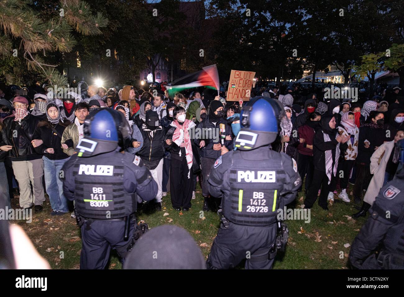 Centinaia di manifestanti filo-palestinesi si sono riuniti nei pressi della Fontana di Nettuno presso Alexanderplatz nel centro di Berlino martedì 7 ottobre 2025, nonostante il divieto della polizia alla manifestazione, in occasione del secondo anniversario degli attacchi terroristici di Hamas contro Israele. I partecipanti hanno cantato slogan come "Gloria alla resistenza", "Intifada fino alla vittoria" e "dal fiume al mare, la Palestina sarà libera”. Gli scontri scoppiarono quando gli ufficiali si trasferirono per disperdere il raduno, portando a numerosi arresti e scontri. La scena è diventata tesa e caotica mentre i manifestanti resistevano agli ordini della polizia. Il momento del rally o Foto Stock Centinaia di manifestanti filo-palestinesi si sono riuniti nei pressi della Fontana di Nettuno presso Alexanderplatz nel centro di Berlino martedì 7 ottobre 2025, nonostante il divieto della polizia alla manifestazione, in occasione del secondo anniversario degli attacchi terroristici di Hamas contro Israele. I partecipanti hanno cantato slogan come "Gloria alla resistenza", "Intifada fino alla vittoria" e "dal fiume al mare, la Palestina sarà libera”. Gli scontri scoppiarono quando gli ufficiali si trasferirono per disperdere il raduno, portando a numerosi arresti e scontri. La scena è diventata tesa e caotica mentre i manifestanti resistevano agli ordini della polizia. Il momento del rally o Foto Stock
