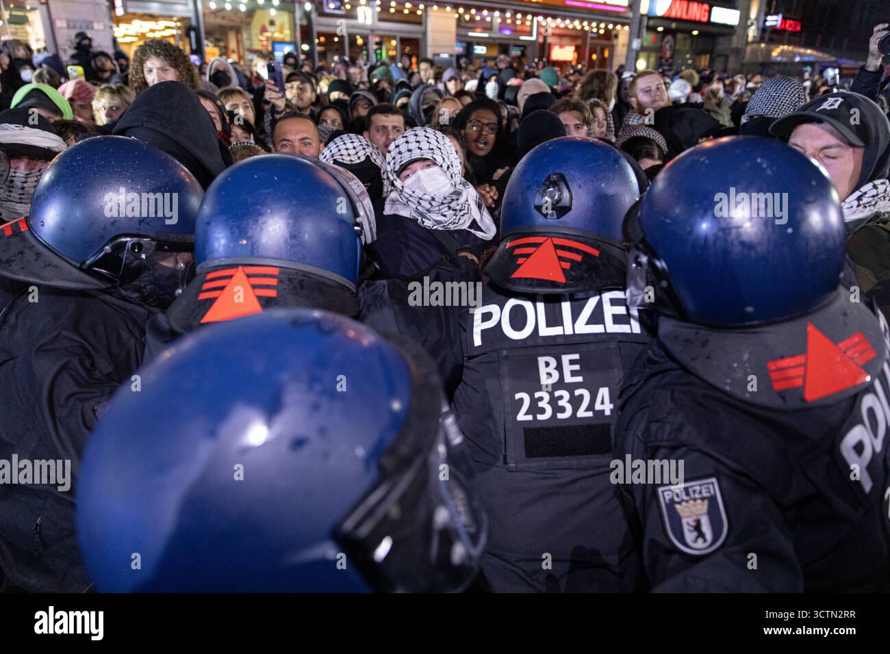 Centinaia di manifestanti filo-palestinesi si sono riuniti nei pressi della Fontana di Nettuno presso Alexanderplatz nel centro di Berlino martedì 7 ottobre 2025, nonostante il divieto della polizia alla manifestazione, in occasione del secondo anniversario degli attacchi terroristici di Hamas contro Israele. I partecipanti hanno cantato slogan come "Gloria alla resistenza", "Intifada fino alla vittoria" e "dal fiume al mare, la Palestina sarà libera”. Gli scontri scoppiarono quando gli ufficiali si trasferirono per disperdere il raduno, portando a numerosi arresti e scontri. La scena è diventata tesa e caotica mentre i manifestanti resistevano agli ordini della polizia. Il momento del rally o Foto Stock Centinaia di manifestanti filo-palestinesi si sono riuniti nei pressi della Fontana di Nettuno presso Alexanderplatz nel centro di Berlino martedì 7 ottobre 2025, nonostante il divieto della polizia alla manifestazione, in occasione del secondo anniversario degli attacchi terroristici di Hamas contro Israele. I partecipanti hanno cantato slogan come "Gloria alla resistenza", "Intifada fino alla vittoria" e "dal fiume al mare, la Palestina sarà libera”. Gli scontri scoppiarono quando gli ufficiali si trasferirono per disperdere il raduno, portando a numerosi arresti e scontri. La scena è diventata tesa e caotica mentre i manifestanti resistevano agli ordini della polizia. Il momento del rally o Foto Stock