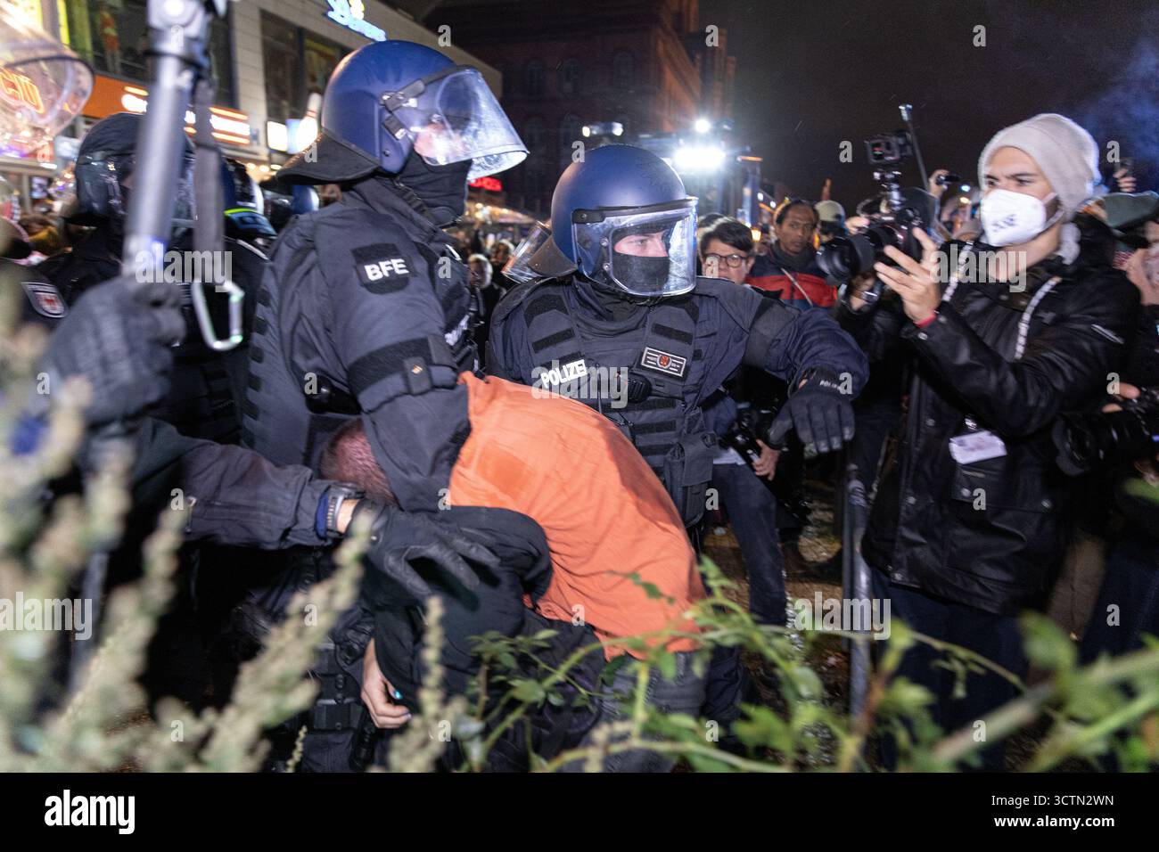 Centinaia di manifestanti filo-palestinesi si sono riuniti nei pressi della Fontana di Nettuno presso Alexanderplatz nel centro di Berlino martedì 7 ottobre 2025, nonostante il divieto della polizia alla manifestazione, in occasione del secondo anniversario degli attacchi terroristici di Hamas contro Israele. I partecipanti hanno cantato slogan come "Gloria alla resistenza", "Intifada fino alla vittoria" e "dal fiume al mare, la Palestina sarà libera”. Gli scontri scoppiarono quando gli ufficiali si trasferirono per disperdere il raduno, portando a numerosi arresti e scontri. La scena è diventata tesa e caotica mentre i manifestanti resistevano agli ordini della polizia. Il momento del rally o Foto Stock Centinaia di manifestanti filo-palestinesi si sono riuniti nei pressi della Fontana di Nettuno presso Alexanderplatz nel centro di Berlino martedì 7 ottobre 2025, nonostante il divieto della polizia alla manifestazione, in occasione del secondo anniversario degli attacchi terroristici di Hamas contro Israele. I partecipanti hanno cantato slogan come "Gloria alla resistenza", "Intifada fino alla vittoria" e "dal fiume al mare, la Palestina sarà libera”. Gli scontri scoppiarono quando gli ufficiali si trasferirono per disperdere il raduno, portando a numerosi arresti e scontri. La scena è diventata tesa e caotica mentre i manifestanti resistevano agli ordini della polizia. Il momento del rally o Foto Stock