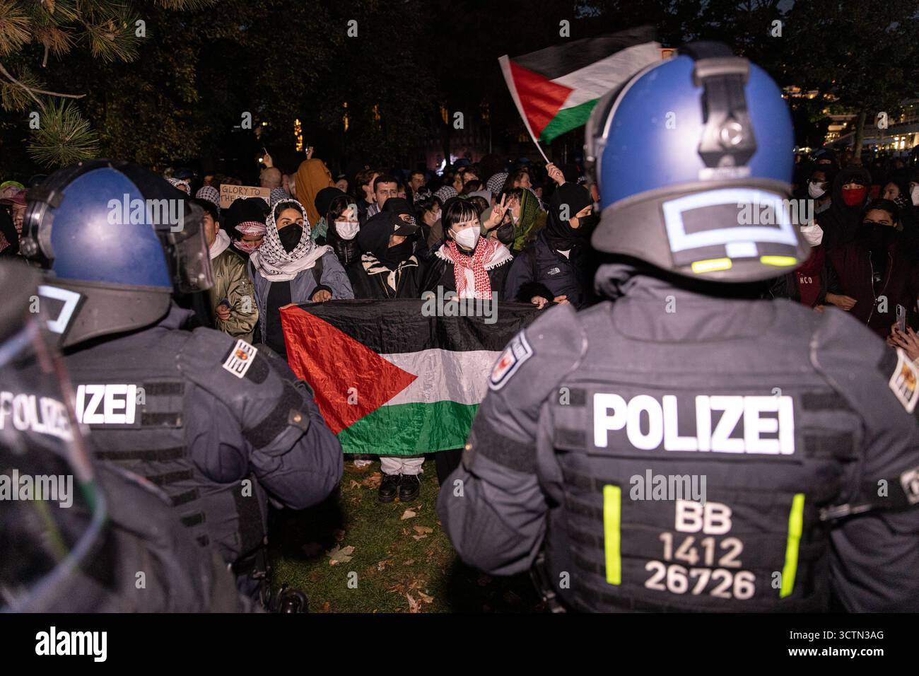 Centinaia di manifestanti filo-palestinesi si sono riuniti nei pressi della Fontana di Nettuno presso Alexanderplatz nel centro di Berlino martedì 7 ottobre 2025, nonostante il divieto della polizia alla manifestazione, in occasione del secondo anniversario degli attacchi terroristici di Hamas contro Israele. I partecipanti hanno cantato slogan come "Gloria alla resistenza", "Intifada fino alla vittoria" e "dal fiume al mare, la Palestina sarà libera”. Gli scontri scoppiarono quando gli ufficiali si trasferirono per disperdere il raduno, portando a numerosi arresti e scontri. La scena è diventata tesa e caotica mentre i manifestanti resistevano agli ordini della polizia. Il momento del rally o Foto Stock Centinaia di manifestanti filo-palestinesi si sono riuniti nei pressi della Fontana di Nettuno presso Alexanderplatz nel centro di Berlino martedì 7 ottobre 2025, nonostante il divieto della polizia alla manifestazione, in occasione del secondo anniversario degli attacchi terroristici di Hamas contro Israele. I partecipanti hanno cantato slogan come "Gloria alla resistenza", "Intifada fino alla vittoria" e "dal fiume al mare, la Palestina sarà libera”. Gli scontri scoppiarono quando gli ufficiali si trasferirono per disperdere il raduno, portando a numerosi arresti e scontri. La scena è diventata tesa e caotica mentre i manifestanti resistevano agli ordini della polizia. Il momento del rally o Foto Stock