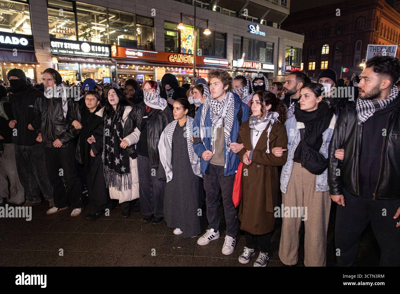 Centinaia di manifestanti filo-palestinesi si sono riuniti nei pressi della Fontana di Nettuno presso Alexanderplatz nel centro di Berlino martedì 7 ottobre 2025, nonostante il divieto della polizia alla manifestazione, in occasione del secondo anniversario degli attacchi terroristici di Hamas contro Israele. I partecipanti hanno cantato slogan come "Gloria alla resistenza", "Intifada fino alla vittoria" e "dal fiume al mare, la Palestina sarà libera”. Gli scontri scoppiarono quando gli ufficiali si trasferirono per disperdere il raduno, portando a numerosi arresti e scontri. La scena è diventata tesa e caotica mentre i manifestanti resistevano agli ordini della polizia. Il momento del rally o Foto Stock Centinaia di manifestanti filo-palestinesi si sono riuniti nei pressi della Fontana di Nettuno presso Alexanderplatz nel centro di Berlino martedì 7 ottobre 2025, nonostante il divieto della polizia alla manifestazione, in occasione del secondo anniversario degli attacchi terroristici di Hamas contro Israele. I partecipanti hanno cantato slogan come "Gloria alla resistenza", "Intifada fino alla vittoria" e "dal fiume al mare, la Palestina sarà libera”. Gli scontri scoppiarono quando gli ufficiali si trasferirono per disperdere il raduno, portando a numerosi arresti e scontri. La scena è diventata tesa e caotica mentre i manifestanti resistevano agli ordini della polizia. Il momento del rally o Foto Stock
