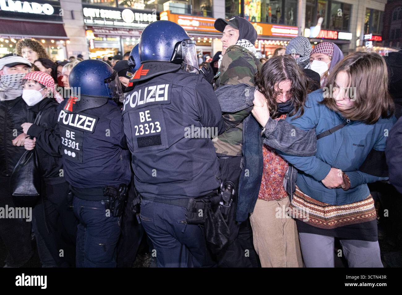 Centinaia di manifestanti filo-palestinesi si sono riuniti nei pressi della Fontana di Nettuno presso Alexanderplatz nel centro di Berlino martedì 7 ottobre 2025, nonostante il divieto della polizia alla manifestazione, in occasione del secondo anniversario degli attacchi terroristici di Hamas contro Israele. I partecipanti hanno cantato slogan come "Gloria alla resistenza", "Intifada fino alla vittoria" e "dal fiume al mare, la Palestina sarà libera”. Gli scontri scoppiarono quando gli ufficiali si trasferirono per disperdere il raduno, portando a numerosi arresti e scontri. La scena è diventata tesa e caotica mentre i manifestanti resistevano agli ordini della polizia. Il momento del rally o Foto Stock Centinaia di manifestanti filo-palestinesi si sono riuniti nei pressi della Fontana di Nettuno presso Alexanderplatz nel centro di Berlino martedì 7 ottobre 2025, nonostante il divieto della polizia alla manifestazione, in occasione del secondo anniversario degli attacchi terroristici di Hamas contro Israele. I partecipanti hanno cantato slogan come "Gloria alla resistenza", "Intifada fino alla vittoria" e "dal fiume al mare, la Palestina sarà libera”. Gli scontri scoppiarono quando gli ufficiali si trasferirono per disperdere il raduno, portando a numerosi arresti e scontri. La scena è diventata tesa e caotica mentre i manifestanti resistevano agli ordini della polizia. Il momento del rally o Foto Stock