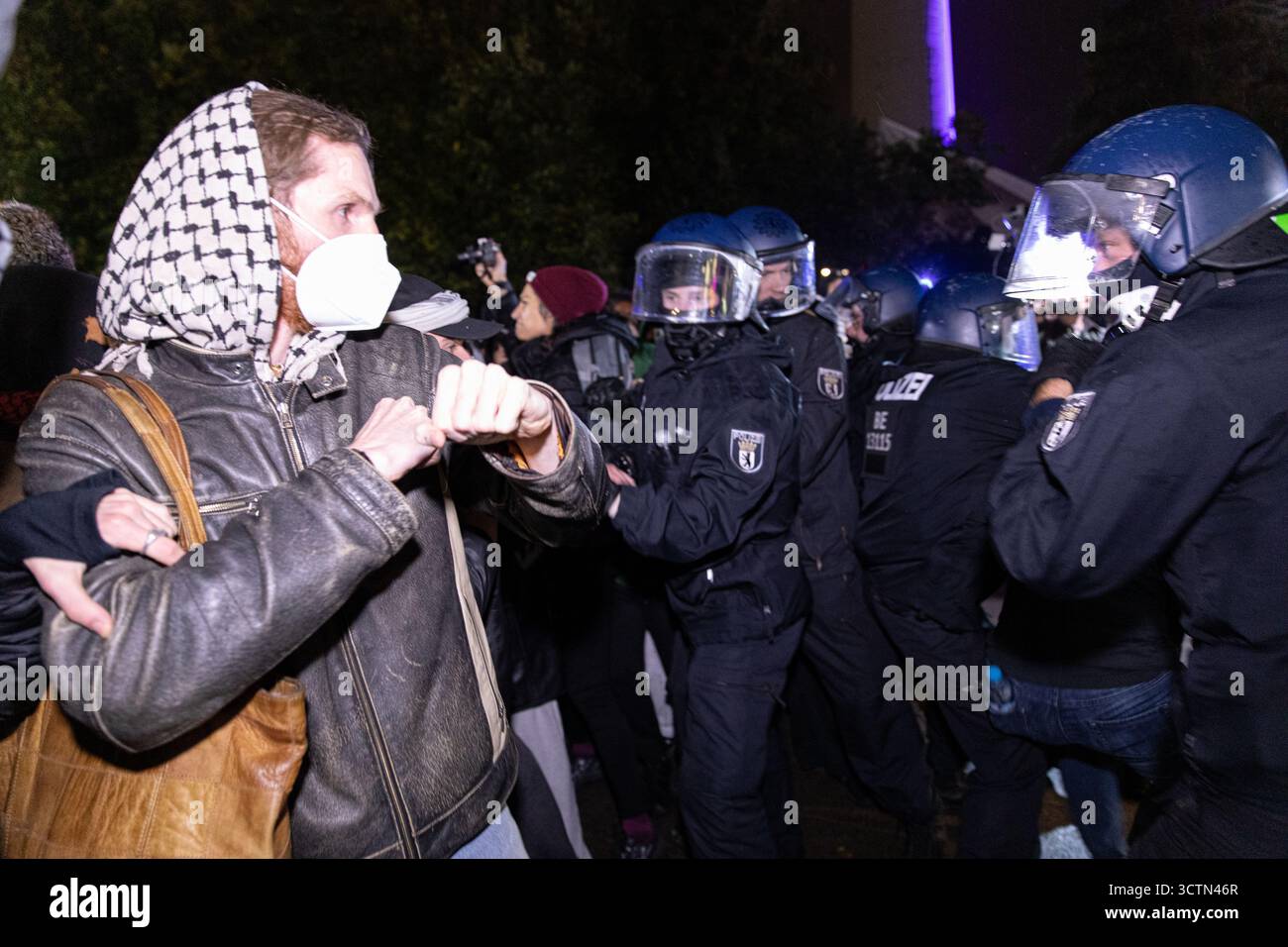 Centinaia di manifestanti filo-palestinesi si sono riuniti nei pressi della Fontana di Nettuno presso Alexanderplatz nel centro di Berlino martedì 7 ottobre 2025, nonostante il divieto della polizia alla manifestazione, in occasione del secondo anniversario degli attacchi terroristici di Hamas contro Israele. I partecipanti hanno cantato slogan come "Gloria alla resistenza", "Intifada fino alla vittoria" e "dal fiume al mare, la Palestina sarà libera”. Gli scontri scoppiarono quando gli ufficiali si trasferirono per disperdere il raduno, portando a numerosi arresti e scontri. La scena è diventata tesa e caotica mentre i manifestanti resistevano agli ordini della polizia. Il momento del rally o Foto Stock Centinaia di manifestanti filo-palestinesi si sono riuniti nei pressi della Fontana di Nettuno presso Alexanderplatz nel centro di Berlino martedì 7 ottobre 2025, nonostante il divieto della polizia alla manifestazione, in occasione del secondo anniversario degli attacchi terroristici di Hamas contro Israele. I partecipanti hanno cantato slogan come "Gloria alla resistenza", "Intifada fino alla vittoria" e "dal fiume al mare, la Palestina sarà libera”. Gli scontri scoppiarono quando gli ufficiali si trasferirono per disperdere il raduno, portando a numerosi arresti e scontri. La scena è diventata tesa e caotica mentre i manifestanti resistevano agli ordini della polizia. Il momento del rally o Foto Stock