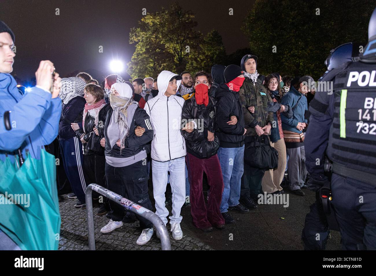 7 ottobre 2025, Berlino, Berlino, Germania: Centinaia di manifestanti filo-palestinesi si sono riuniti nei pressi della Fontana di Nettuno da Alexanderplatz nel centro di Berlino martedì 7 ottobre 2025, nonostante il divieto della polizia alla manifestazione, in occasione del secondo anniversario degli attacchi terroristici di Hamas contro Israele. I partecipanti cantarono slogan come "Gloria alla resistenza", "Intifada fino alla vittoria" e "dal fiume al mare, la Palestina sarà libera". Gli scontri scoppiarono quando gli ufficiali si trasferirono per disperdere il raduno, portando a numerosi arresti e scontri. La scena è diventata tesa e caotica come prote Foto Stock 7 ottobre 2025, Berlino, Berlino, Germania: Centinaia di manifestanti filo-palestinesi si sono riuniti nei pressi della Fontana di Nettuno da Alexanderplatz nel centro di Berlino martedì 7 ottobre 2025, nonostante il divieto della polizia alla manifestazione, in occasione del secondo anniversario degli attacchi terroristici di Hamas contro Israele. I partecipanti cantarono slogan come "Gloria alla resistenza", "Intifada fino alla vittoria" e "dal fiume al mare, la Palestina sarà libera". Gli scontri scoppiarono quando gli ufficiali si trasferirono per disperdere il raduno, portando a numerosi arresti e scontri. La scena è diventata tesa e caotica come prote Foto Stock