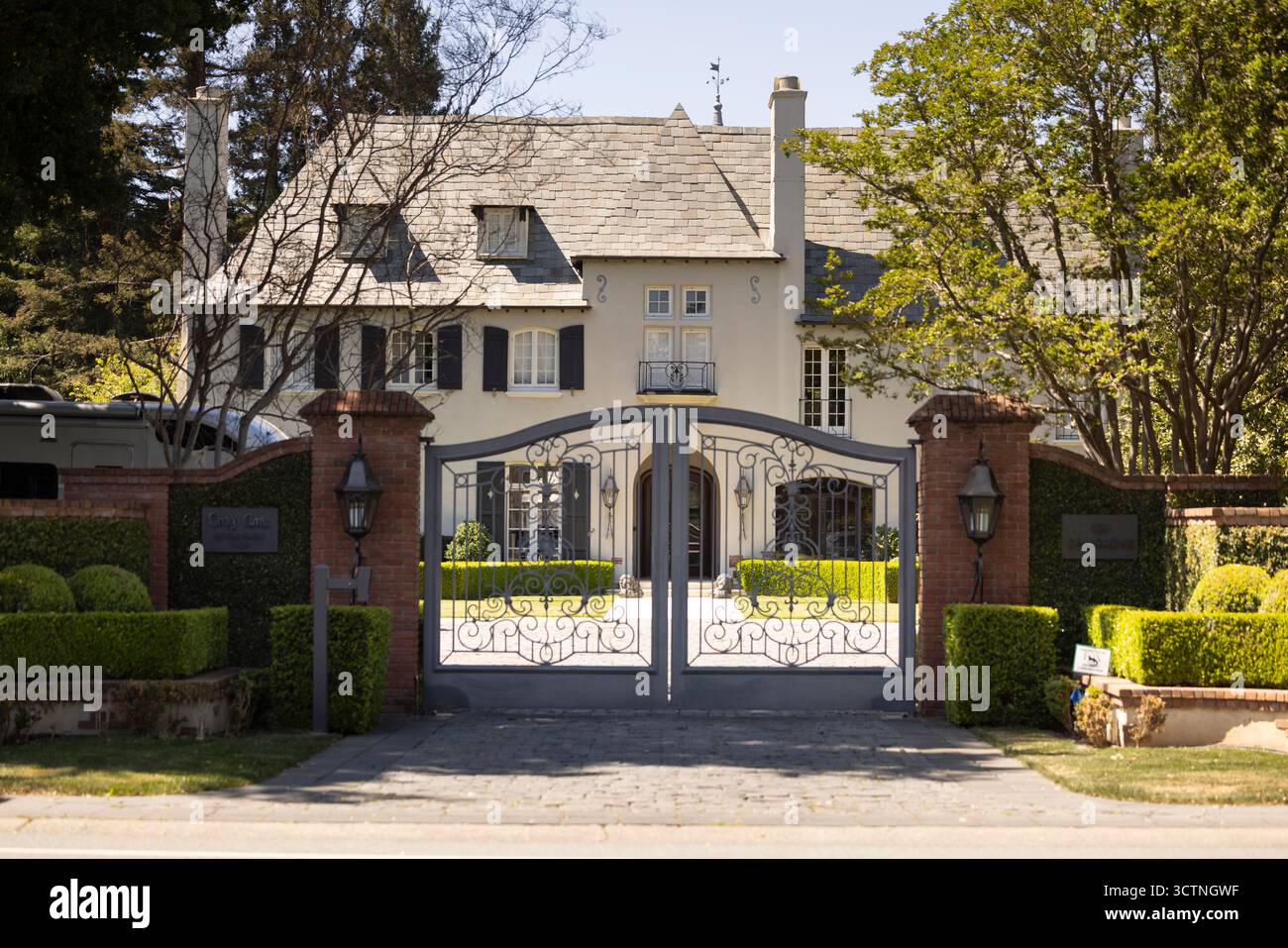 Atherton, California, Stati Uniti - 18 aprile 2025: La luce del pomeriggio splende su una villa recintata nel cuore del quartiere residenziale. Foto Stock