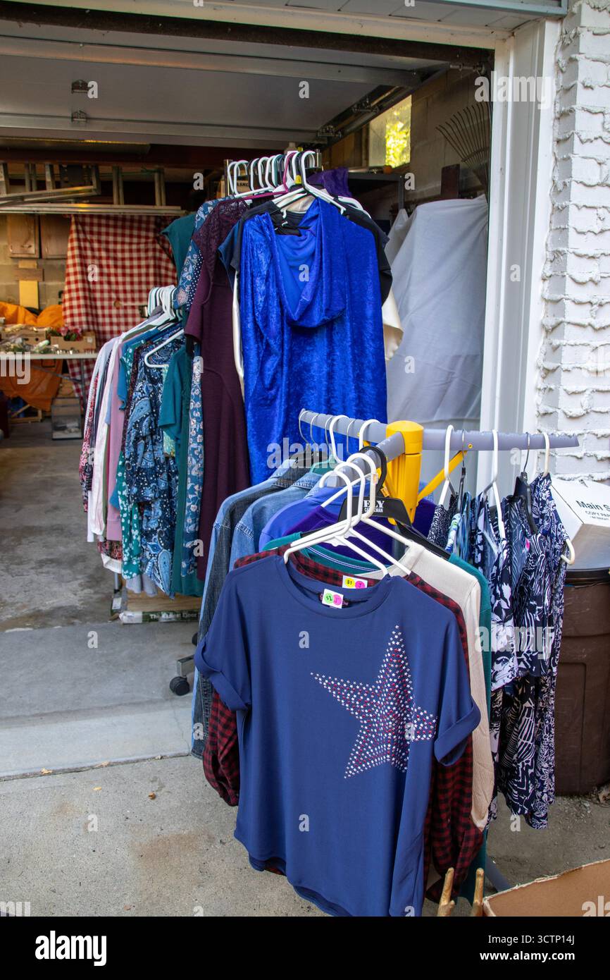 Vestiti appesi in vendita in un garage in una casa di periferia nel Midwest degli Stati Uniti. Foto Stock