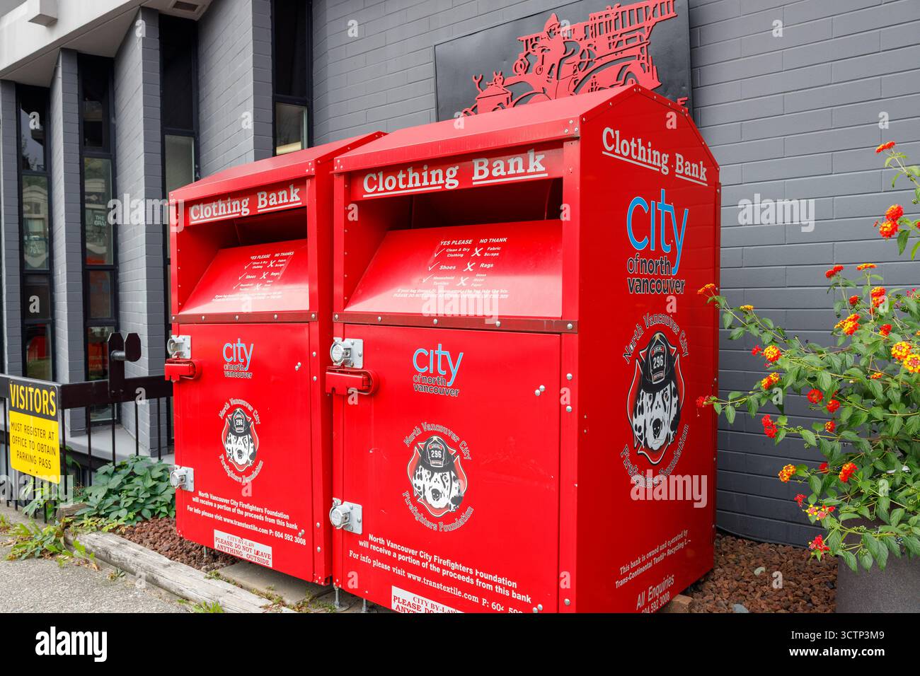 Vancouver, Canada - 25 settembre 2025: Bidoni di donazione di vestiti rossi gemelli per la North Vancouver Firefighters Foundation Foto Stock