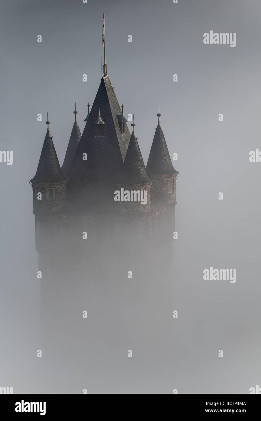 Primo piano ad alto angolo della torre principale del castello di Cochem, che attraversa basse nuvole, con il resto del castello in gran parte nascosto Foto Stock
