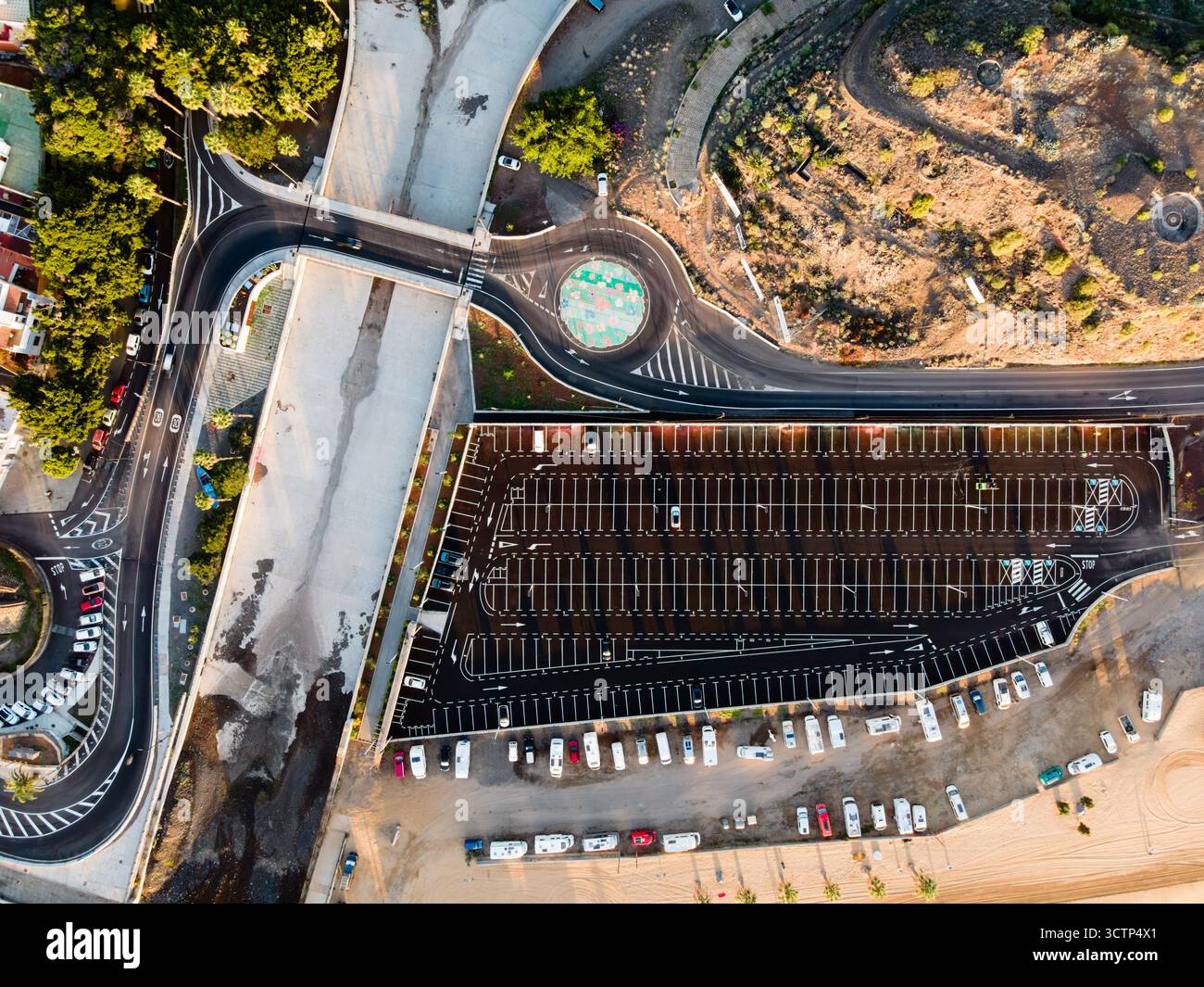 Ripresa mattutina dall'alto di un parcheggio, di una rotatoria circolare e di un drenaggio delle tempeste a San Andrés, Tenerife, per catturare il layout urbano e le infrastrutture Foto Stock