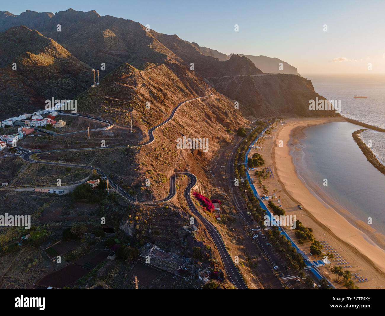 Vista aerea di una tortuosa strada di montagna lungo la costa meridionale di Tenerife vicino a San Andrés, con scogliere spettacolari e l'oceano Foto Stock
