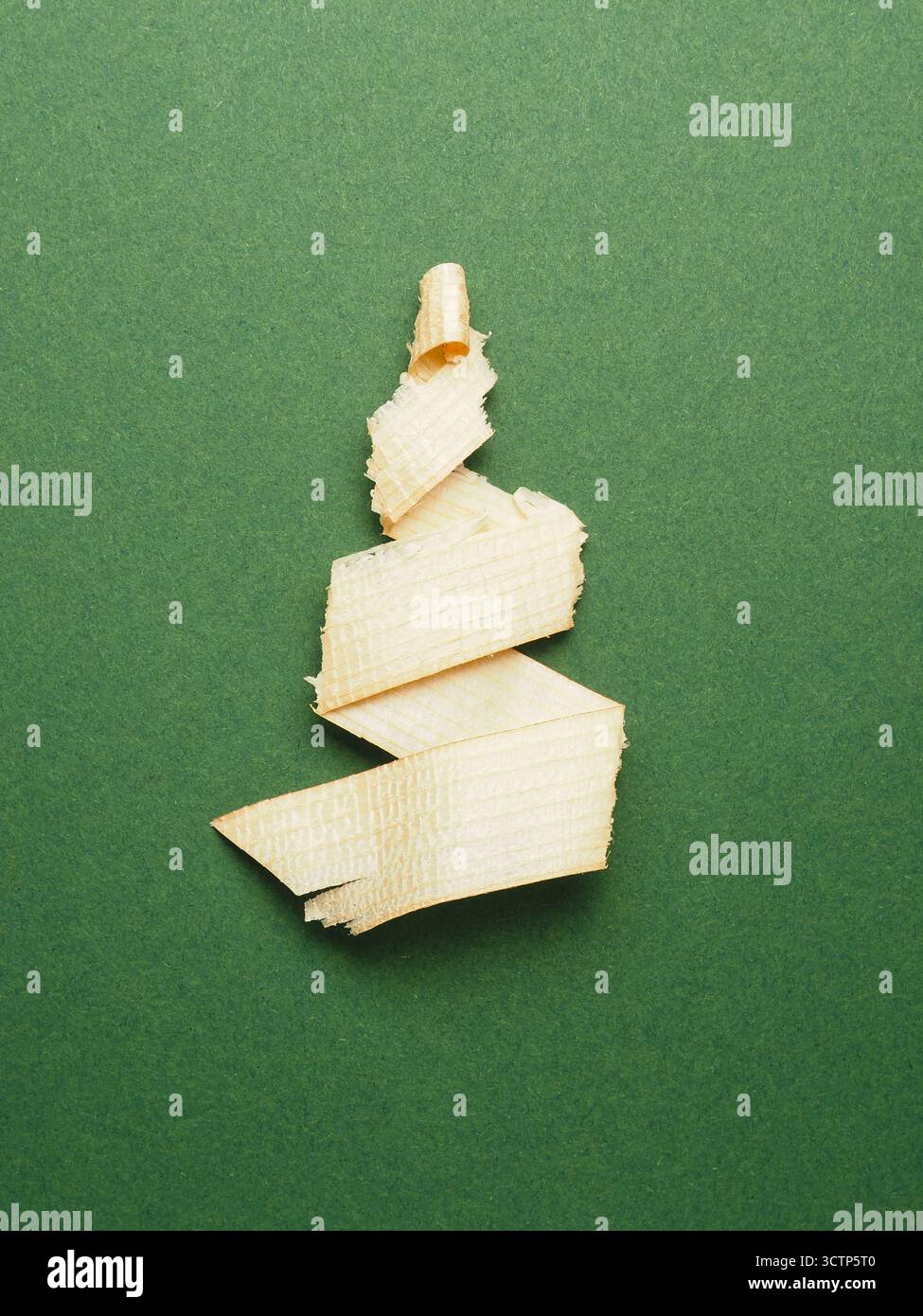 Trucioli di legno a forma di albero di Natale su sfondo di carta verde, concetto di auguri natalizi Foto Stock