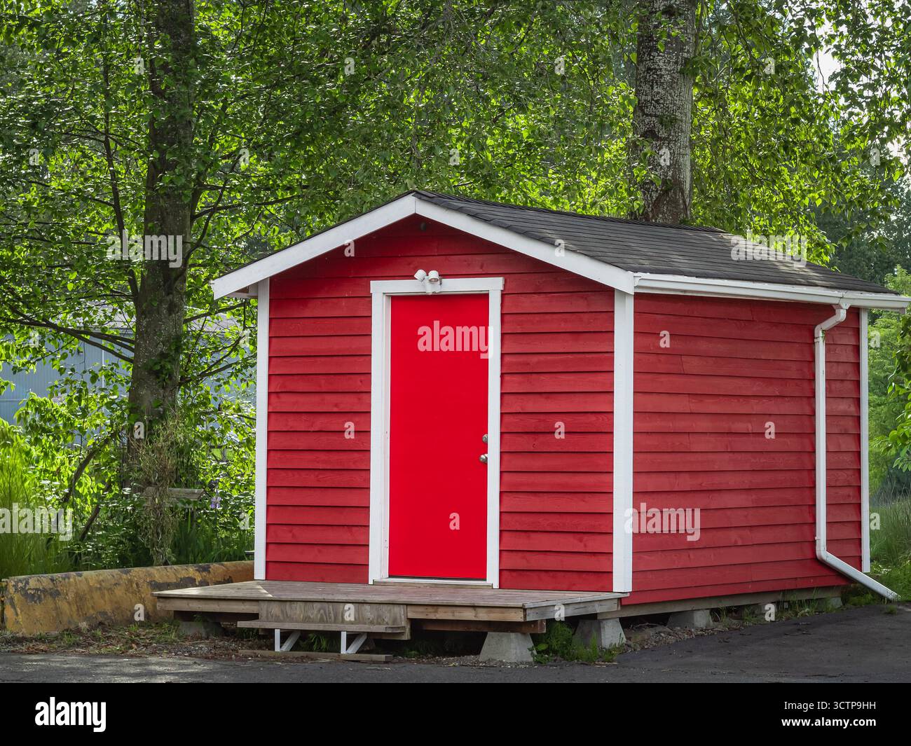 Deposito merci, capannone per la casa, magazzino. Nuovo moderno modello Shed di colore rosso nel cortile posteriore. Capannone in legno per magazzino, piccolo magazzino in legno Foto Stock