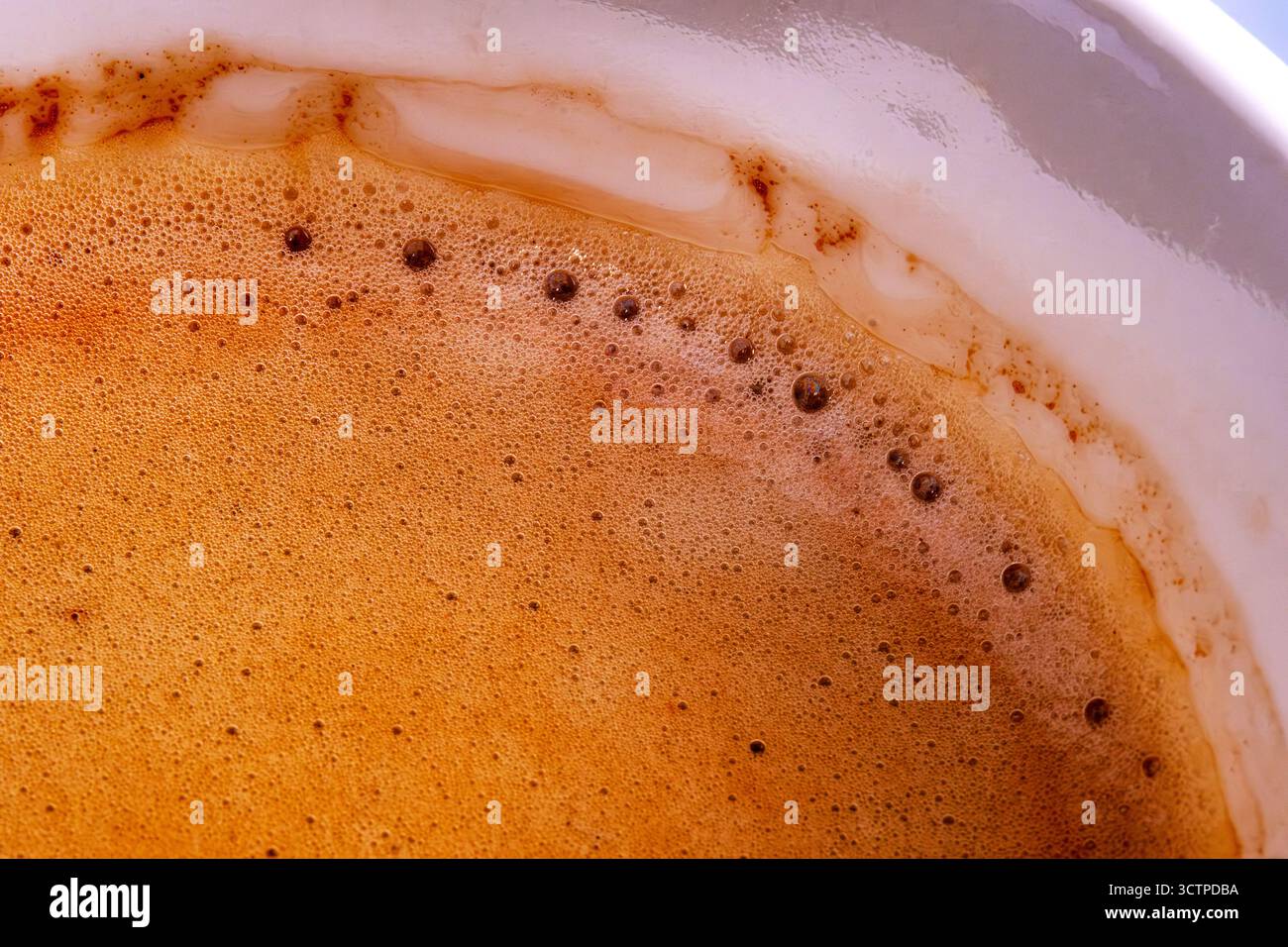 Primo piano della superficie di crema espresso espresso espresso espresso espresso espresso espresso espresso espresso con una ricca crema in una tazza bianca che presenta bolle sottili. Consistenza cremosa e calde tonalità marroni. Foto Stock