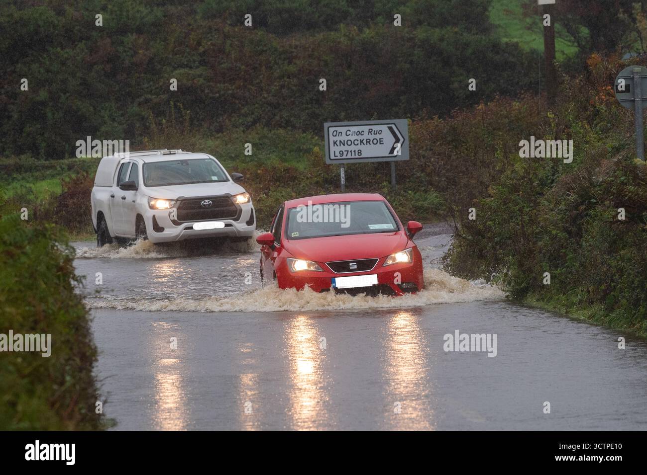 Le auto attraversano le acque alluvionali durante la tempesta Amy sulla N71 fuori Ballydehob, West Cork, Irlanda. Foto Stock