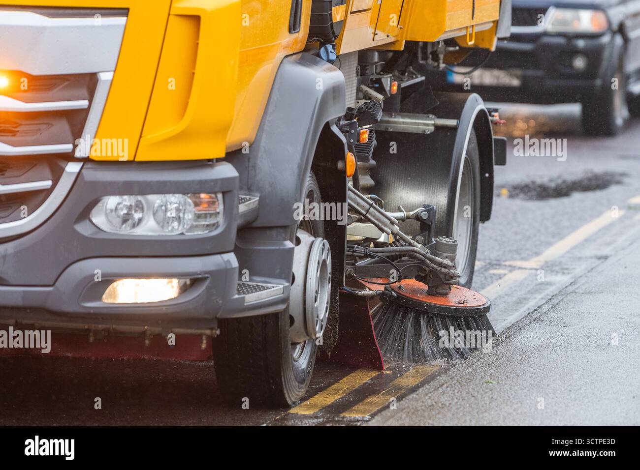 La spazzatrice stradale del Consiglio della contea di Cork pulisce le grondaie dalle foglie vicino ai drenaggi delle tempeste a Bantry, West Cork, Irlanda. Foto Stock