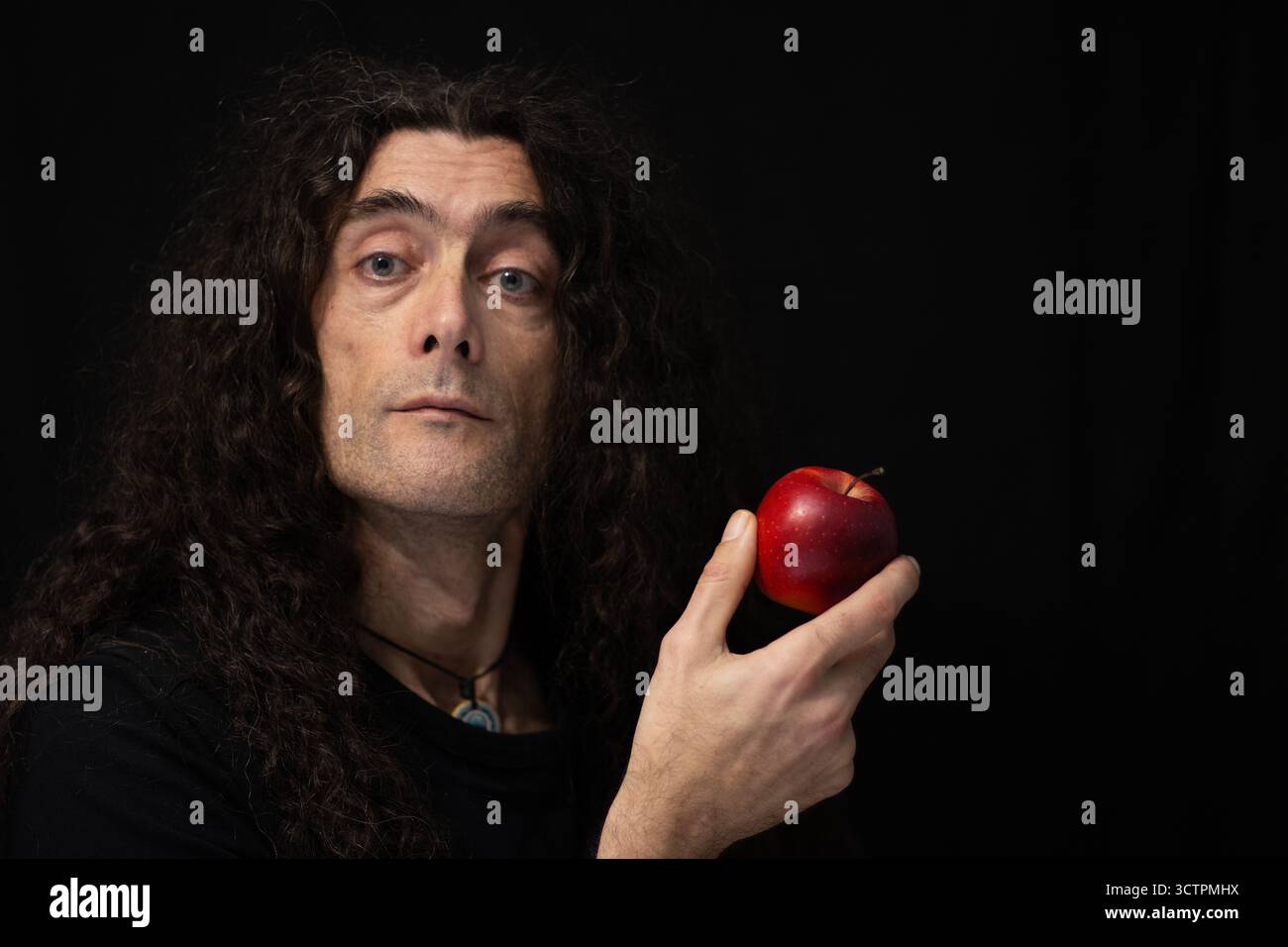 Questo è un ritratto drammatico di un uomo, probabilmente un musicista, caratterizzato da uno stile di illuminazione basso che contrasta un volto ben illuminato e una mano contro un predominio Foto Stock
