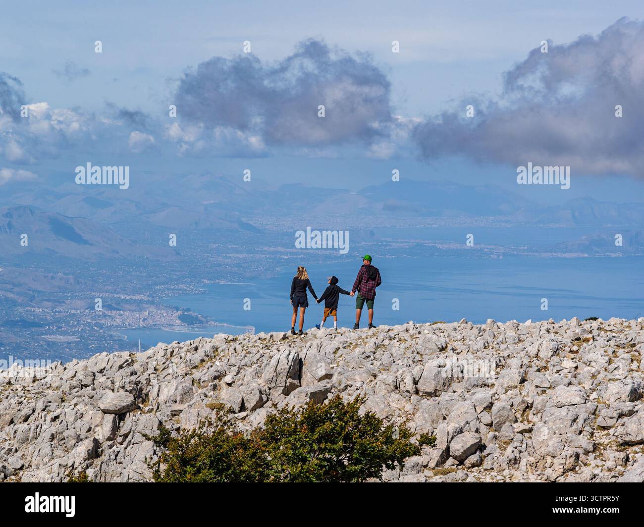 Vista aerea di coppia, famiglia in piedi su una cima siciliana Carbonara con vedute panoramiche del Mar Tirreno, delle scogliere circostanti e del paesaggio lussureggiante Foto Stock
