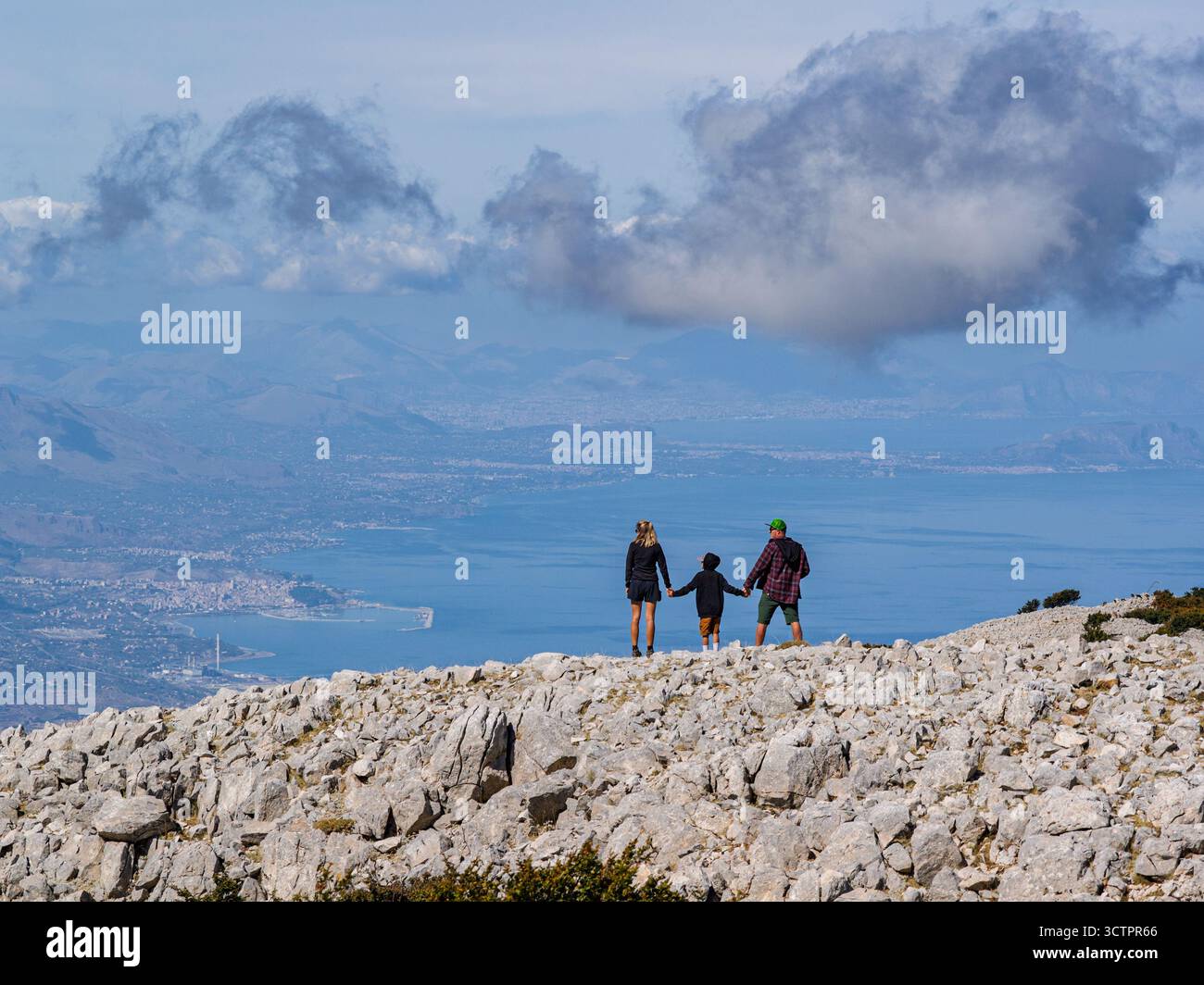 Vista aerea di coppia, famiglia in piedi su una cima siciliana Carbonara con vedute panoramiche del Mar Tirreno, delle scogliere circostanti e del paesaggio lussureggiante Foto Stock