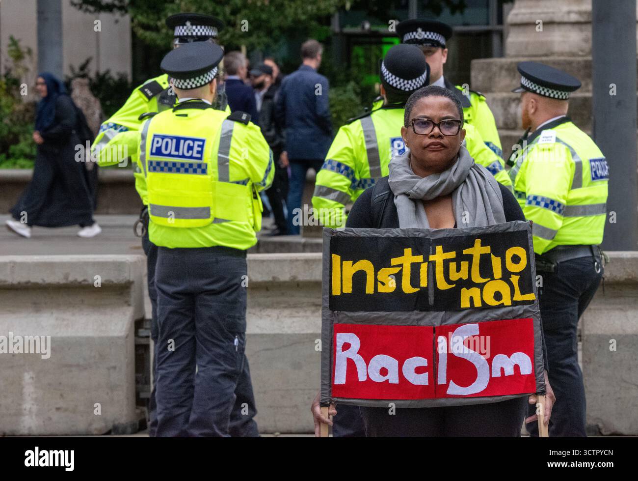 8 ottobre 2025. Manchester, manifestante britannico fuori dalla Conferenza dei Conservatori 2025 in Piazza San Pietro. Il segno dice "razzismo istituzionale". Manchester . Crediti fotografici del Regno Unito: GaryRobertsphotography/Alamy Live News Foto Stock