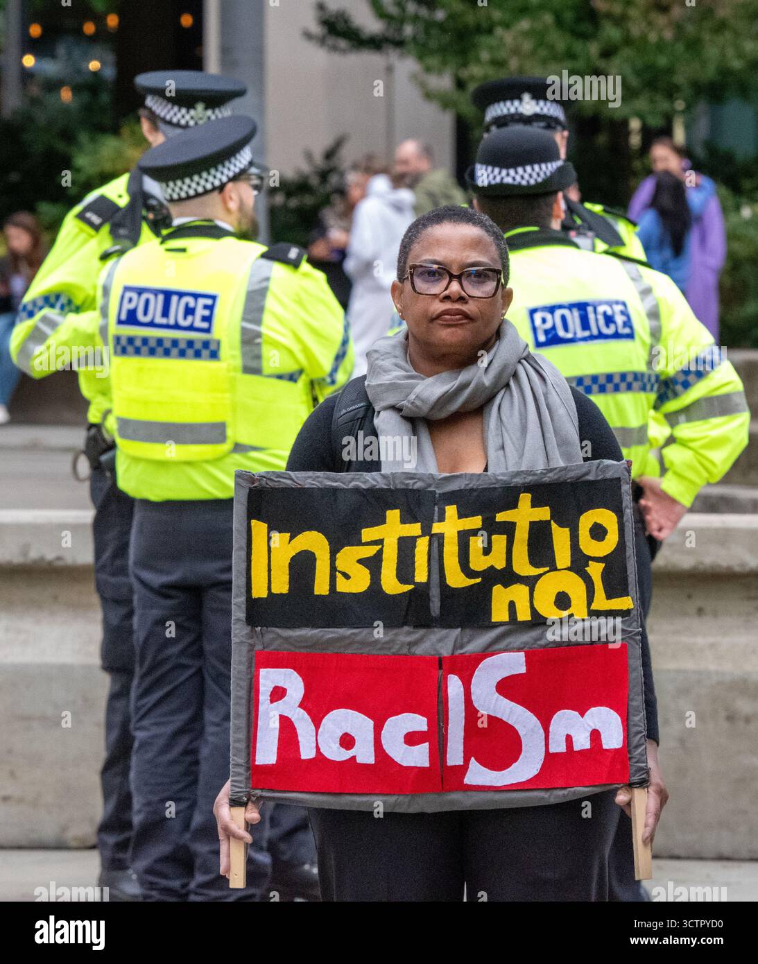 8 ottobre 2025. Manchester, manifestante britannico fuori dalla Conferenza dei Conservatori 2025 in Piazza San Pietro. Il segno dice "razzismo istituzionale". Manchester . Crediti fotografici del Regno Unito: GaryRobertsphotography/Alamy Live News Foto Stock