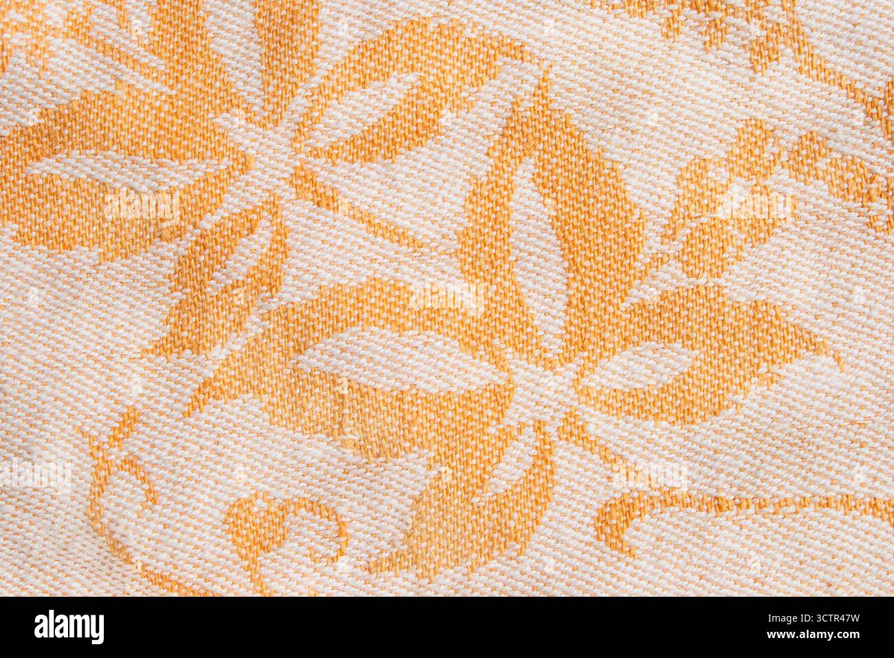 Primo piano in tessuto giallo con stampa floreale come sfondo Foto Stock