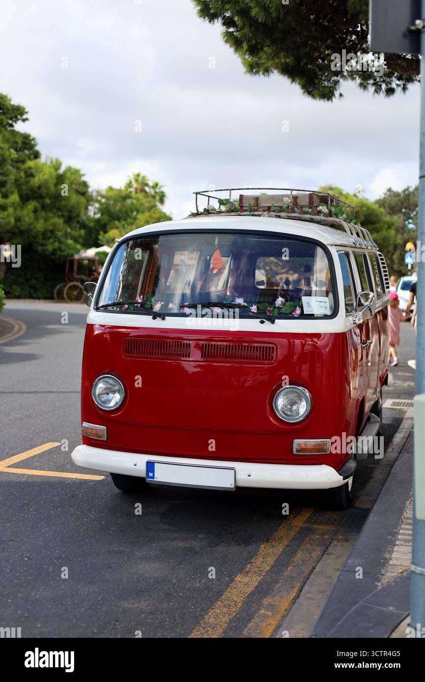 Furgone da trasporto vintage, iconico, rosso e bianco in perfette condizioni con fiori sul cruscotto e targhe vuote Foto Stock