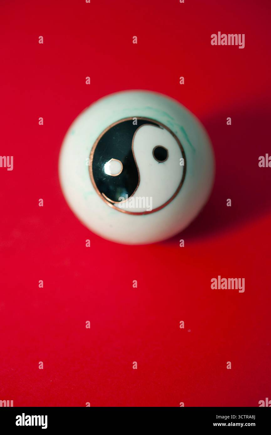 Palla Yin yang su sfondo rosso che simboleggia equilibrio, armonia e dualità nella filosofia cinese Foto Stock