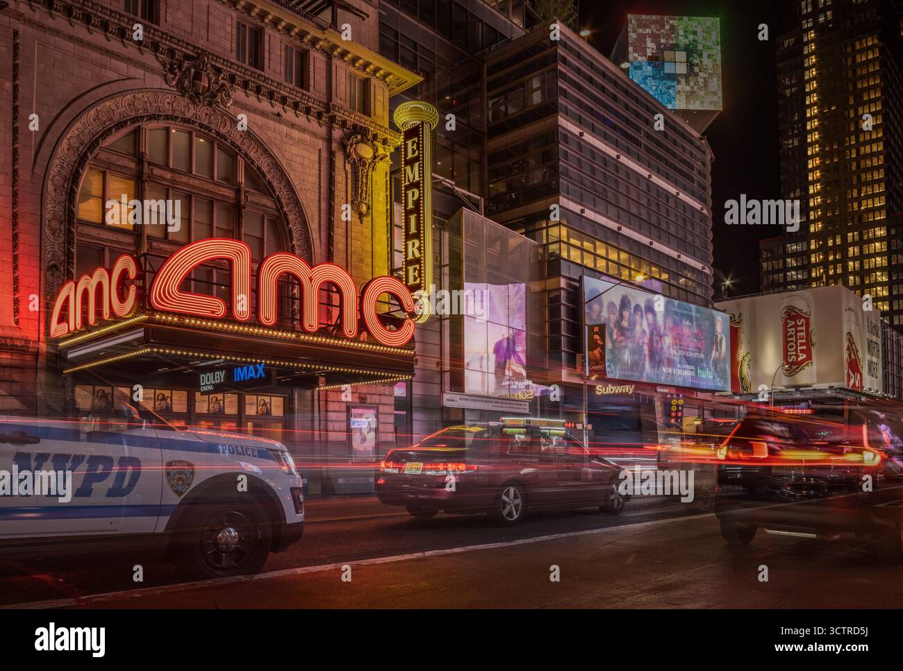 Scena notturna di strada con luci al neon e traffico in movimento a Midtown Manhattan – Editorial Urban Photography of New York City Foto Stock