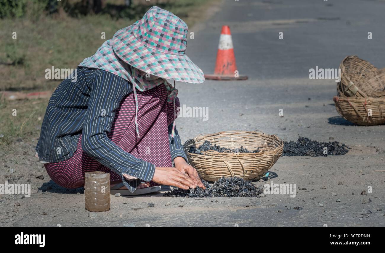 Donna che lavora sulla costruzione di strade a mano nell'area rurale – Fotografia documentaria editoriale del lavoro manuale e della povertà Foto Stock