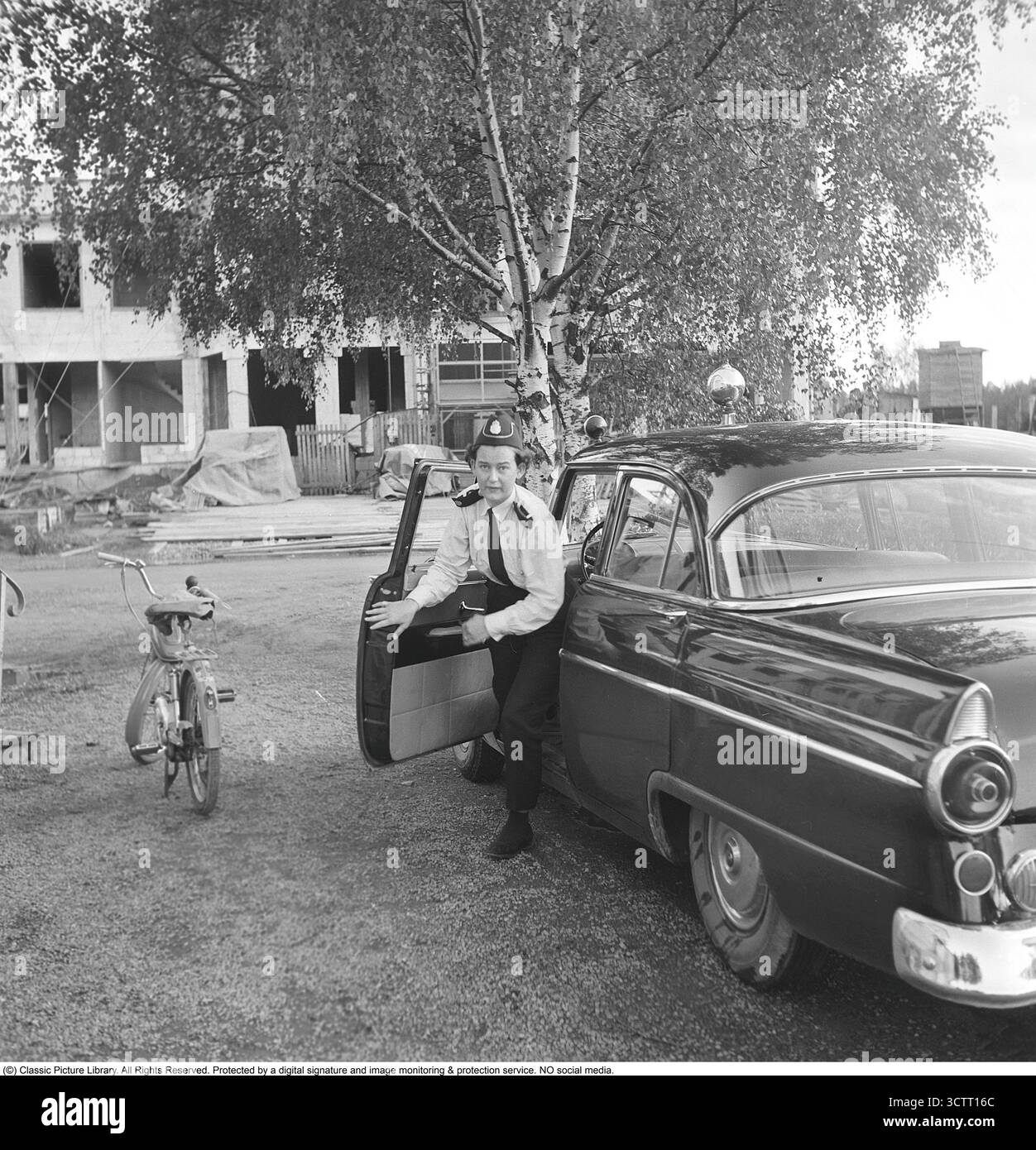 Le prime donne agenti di polizia in Svezia. Una delle primissime donne della polizia svedese al lavoro che lascia l'auto di pattuglia in fretta. Settembre 1956 Foto Stock