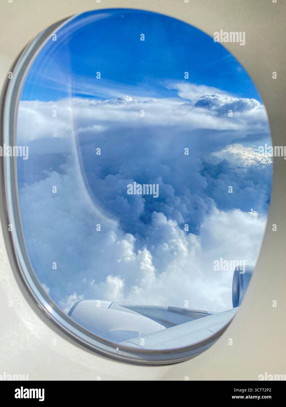 Vista di un passeggero aereo attraverso l'oblò o la finestra sopra il cielo blu con nuvole sparse sull'Oceano Indiano verso l'Australi occidentale Foto Stock