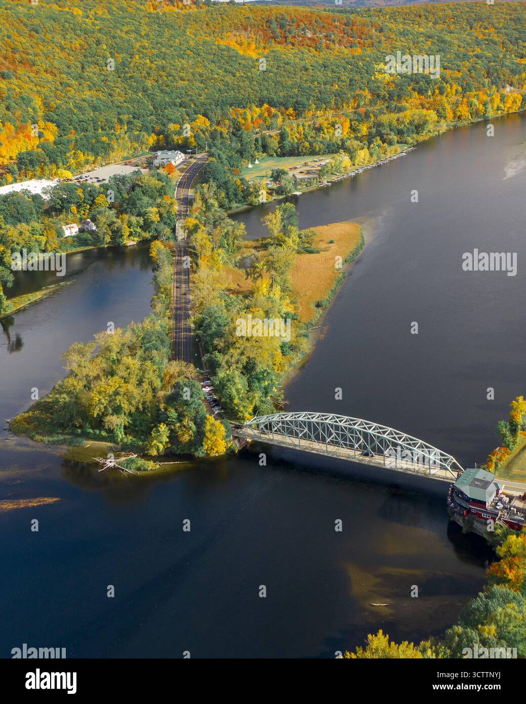 Vista aerea del fiume Connecticut che scorre sotto un ponte d'argento, circondato da un vivace fogliame autunnale, Brattleboro, Vermont, Stati Uniti. Foto Stock