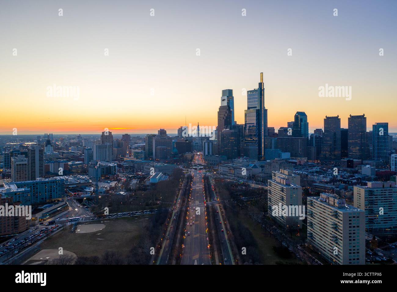 Vista aerea dei grattacieli che piangono il cielo crepuscolo, proiettando lunghe ombre sulle vivaci strade di Center City, Philadelphia, Pennsylvania, Stati Uniti. Foto Stock