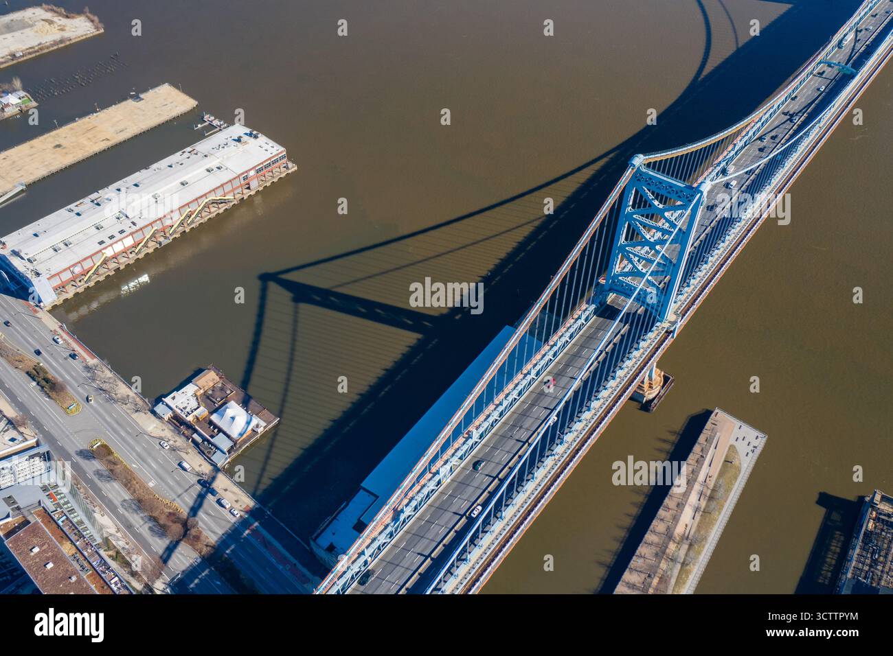 Vista aerea del maestoso ponte blu Ben Franklin che getta una lunga ombra sul fangoso fiume Delaware, Philadelphia, Pennsylvania, Stati Uniti. Foto Stock