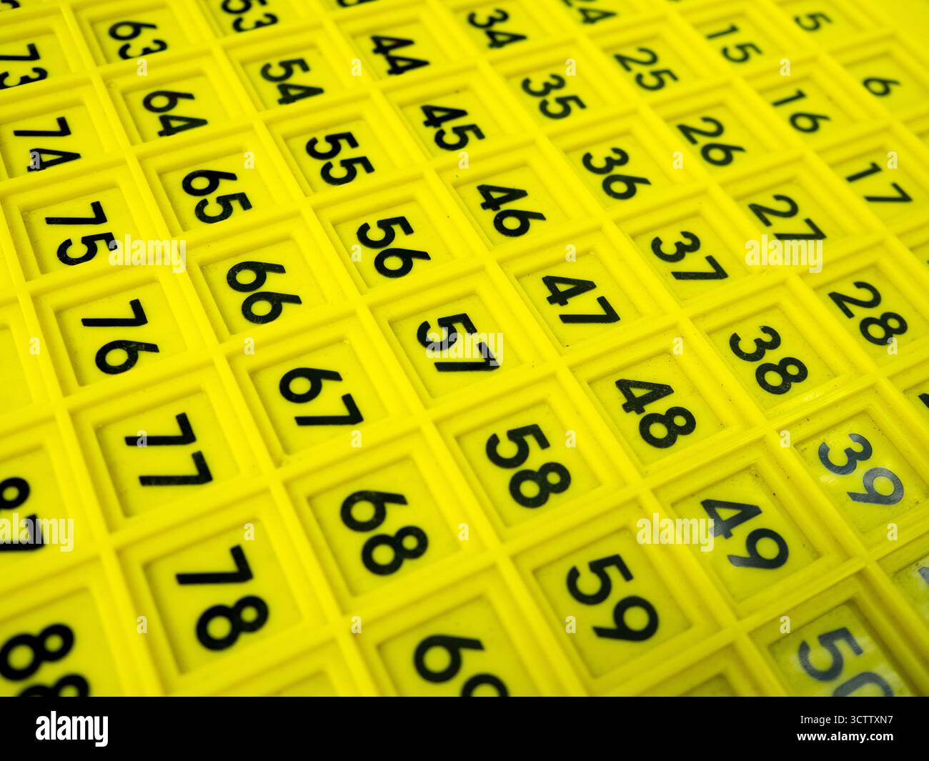 Immagine ravvicinata di una griglia numerica gialla con numeri neri in singoli quadrati di plastica. Comunemente utilizzato come ausilio per l'apprendimento matematico per la preimpostazione Foto Stock