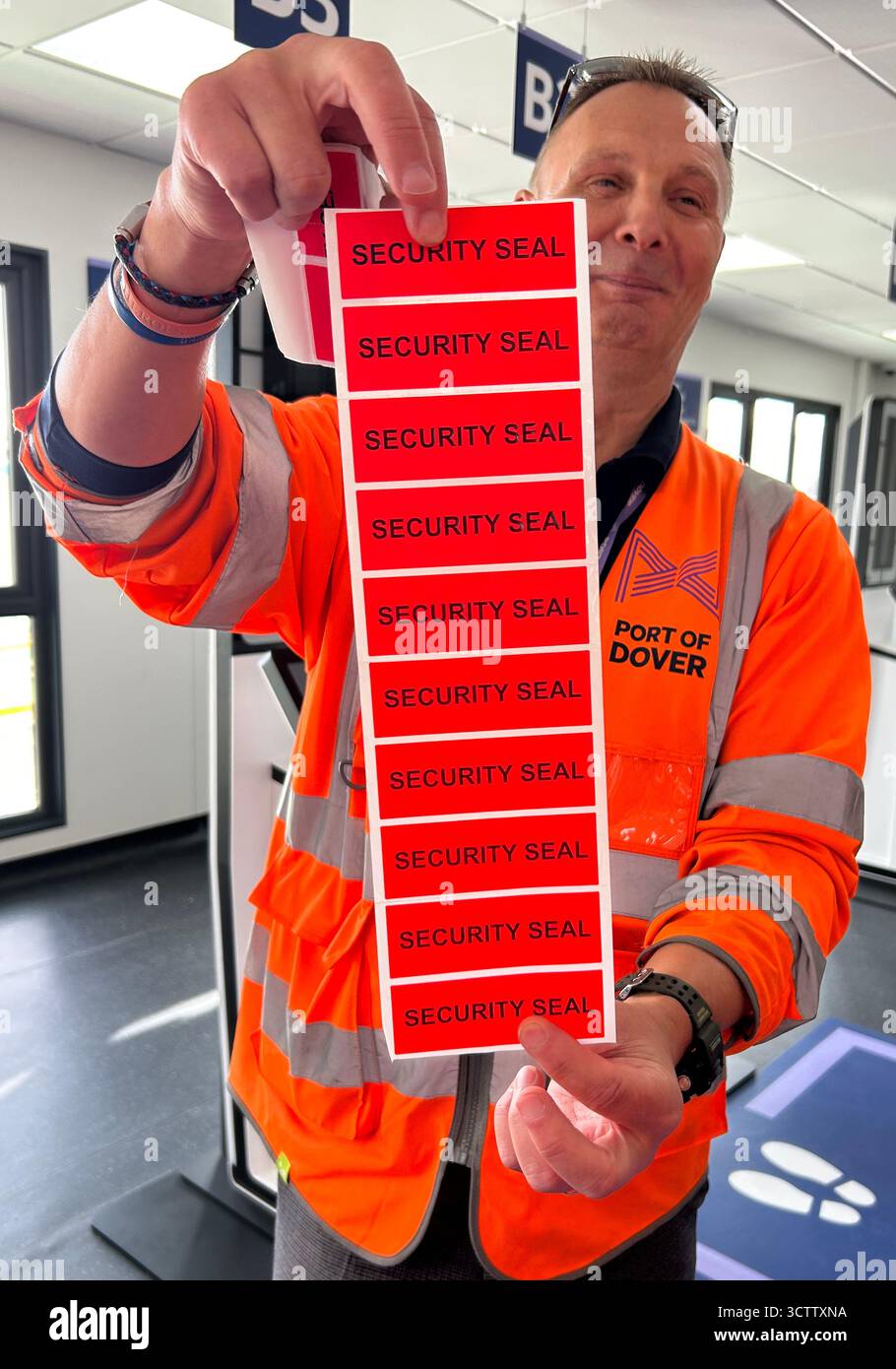 Un funzionario del porto di dover tiene in mano i nuovi adesivi di sicurezza per i pullman, durante un'anteprima della nuova zona del sistema di ingresso/uscita (EES) presso i Western Docks nel porto di dover, nel Kent. Data foto: Mercoledì 8 ottobre 2025. Foto Stock
