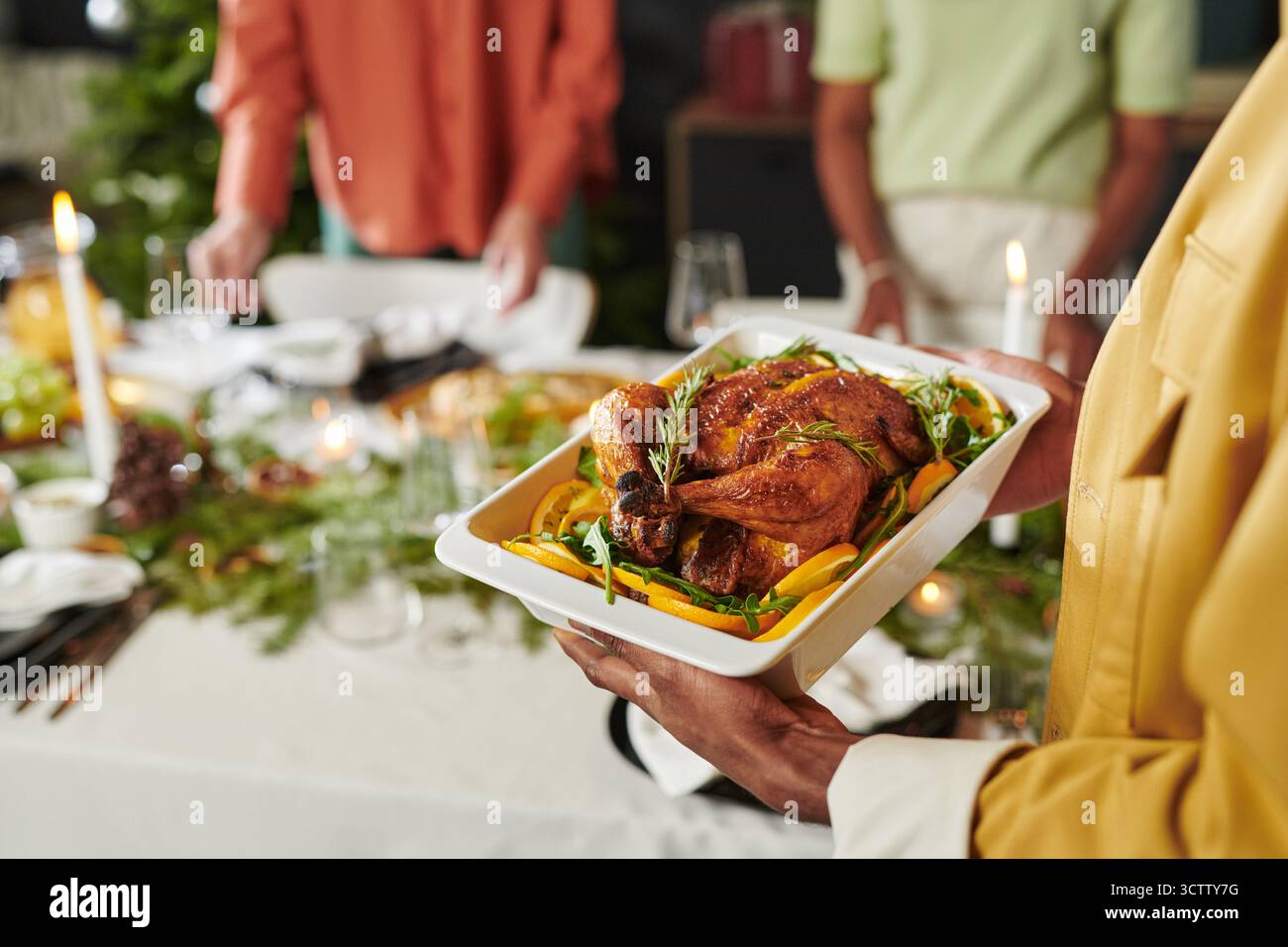 Donna che serve pollo arrosto durante la cena di Natale Foto Stock
