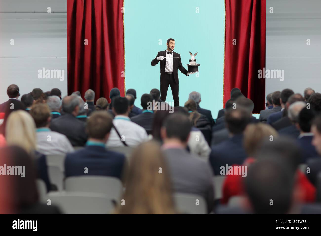 Mago che esegue una trick con un cappello e un coniglio sul palco Foto Stock