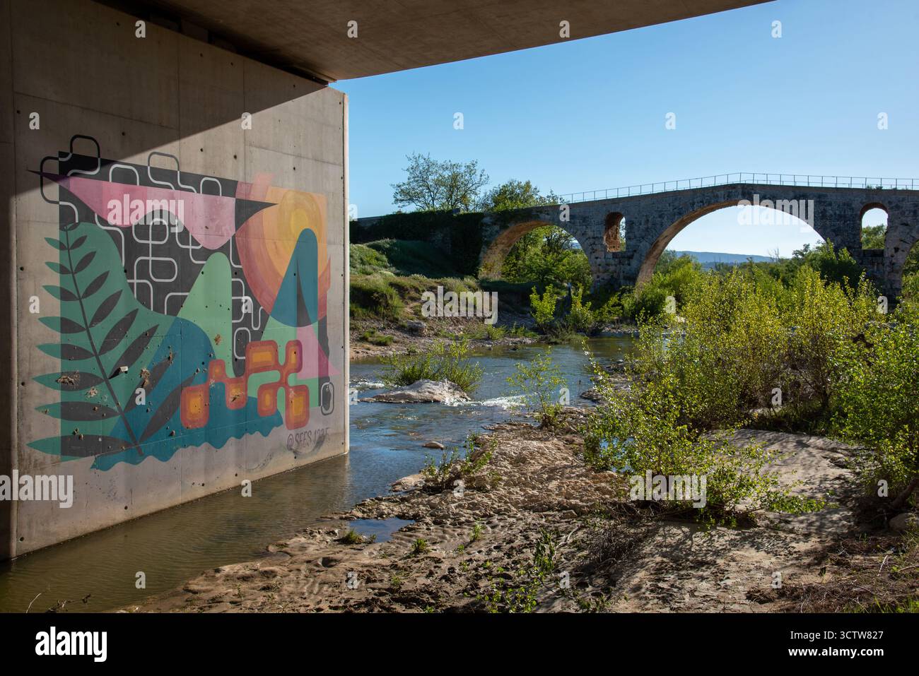 Moderna pittura murale astratta o murale sul ponte stradale accanto alla sagoma del ponte romano Pont Julien nr Bonnieux Luberon Vaucluse Provence Francia Foto Stock