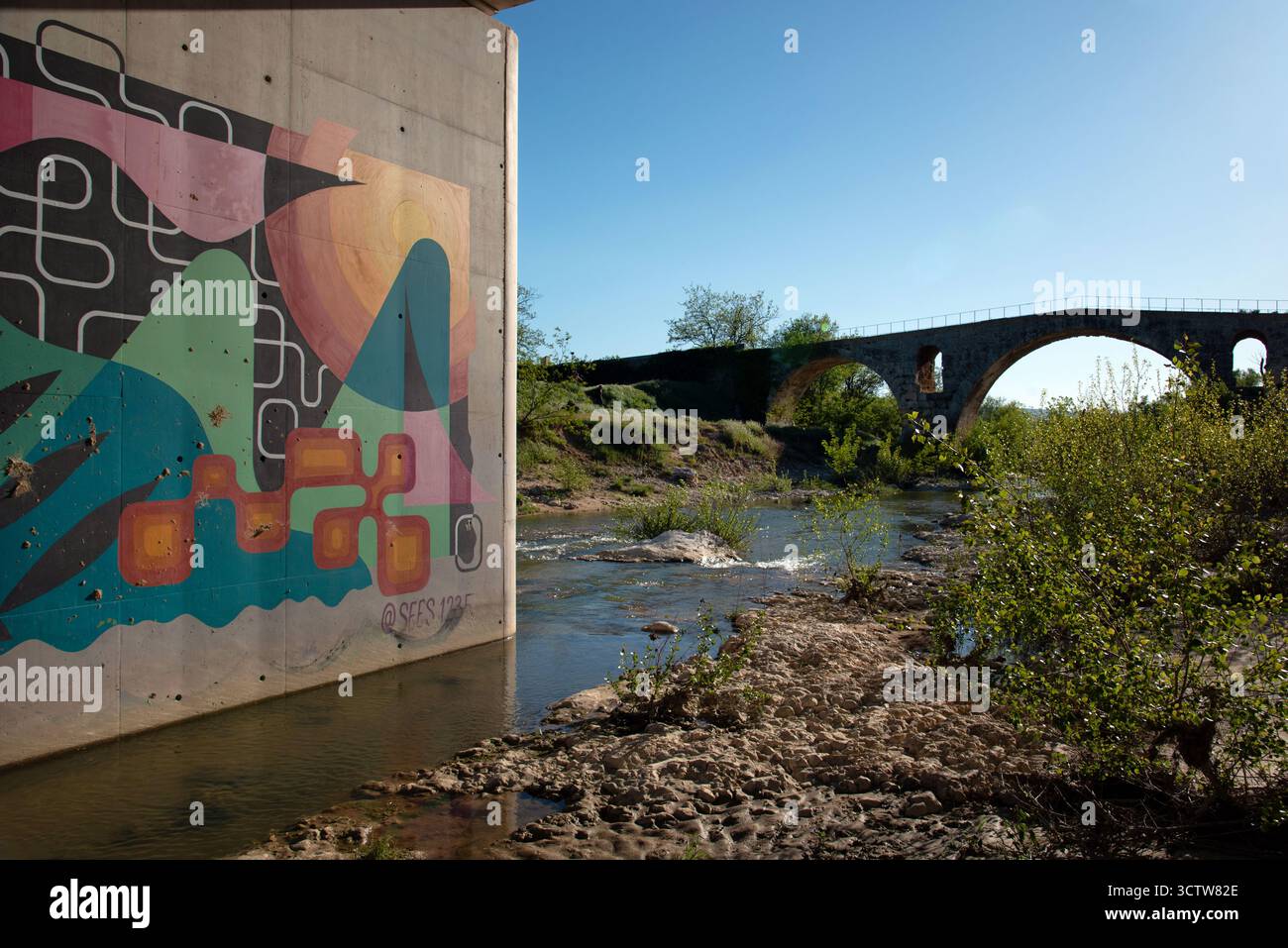 Moderna pittura murale astratta o murale sul ponte stradale accanto alla sagoma del ponte romano Pont Julien nr Bonnieux Luberon Vaucluse Provence Francia Foto Stock