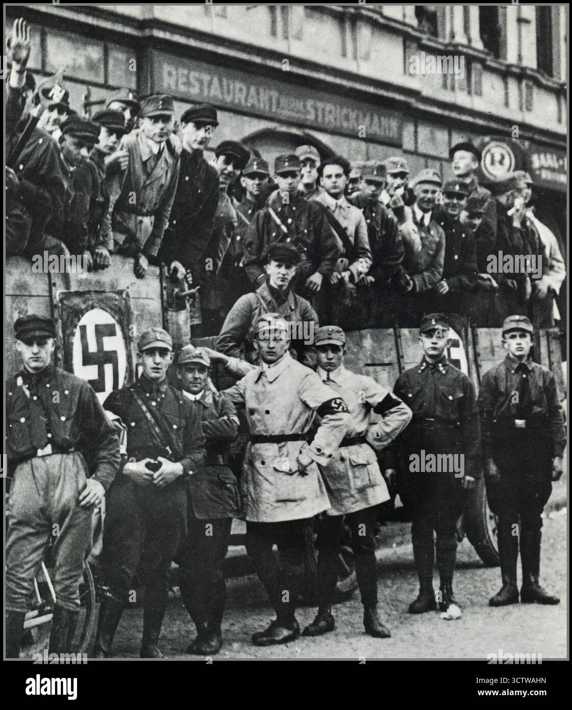 Gruppo nazista delle SA di membri in uniforme della Sturmabteilung (SA, camicie marroni), l'ala paramilitare del partito nazista. Uomini in piedi a bordo e lungo un camion (con rimorchio aggiuntivo) decorati con il simbolo della festa della svastica, che vanno per un tour di propaganda, una riunione di rally, una campagna politica, una dimostrazione, ecc.. Dalla Repubblica di Weimar (Germania) degli anni '1920 (fuori dal ristorante Strickmann) Foto Stock Gruppo nazista delle SA di membri in uniforme della Sturmabteilung (SA, camicie marroni), l'ala paramilitare del partito nazista. Uomini in piedi a bordo e lungo un camion (con rimorchio aggiuntivo) decorati con il simbolo della festa della svastica, che vanno per un tour di propaganda, una riunione di rally, una campagna politica, una dimostrazione, ecc.. Dalla Repubblica di Weimar (Germania) degli anni '1920 (fuori dal ristorante Strickmann) Foto Stock