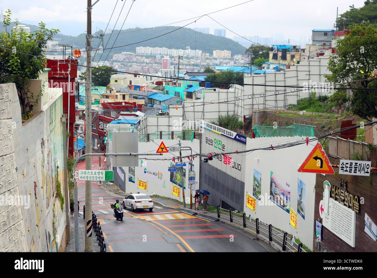 Una fotografia del villaggio culturale di Gamcheon nel distretto di Saha, Busan, Corea del Sud, che cattura le sue strade stratificate, i vicoli contorti simili a labirinti e le case dai colori vivaci che scendono lungo un ripido pendio di montagna. Il villaggio fu originariamente costruito durante gli anni '1920 e '1930, quando l'amministrazione della città di Pusan decise di trasferire le popolazioni della classe operaia, e vide un significativo afflusso di famiglie durante il recupero post-bellico del 1955. Negli ultimi anni, queste case sono state ampiamente restaurate e potenziate per attirare il turismo. 2025. Foto Stock