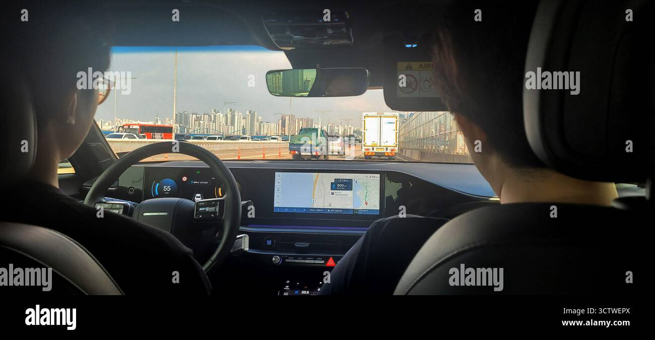 Una fotografia di un conducente che utilizza la tecnologia satnav su un'autostrada vicino a Gyeongju, Corea del Sud. Questa scena mette in evidenza l'integrazione avanzata della tecnologia digitale nelle automobili contemporanee, riflettendo un cambiamento significativo dalle tradizionali mappe cartacee ai display digitali interattivi, migliorando la comodità di guida e la sicurezza. 2025. Foto Stock