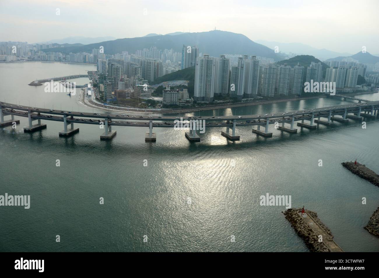 Una fotografia del ponte Gwangan (???, Gwangandaegyo), un ponte sospeso situato a Busan, Corea del Sud. Collega il distretto di Haeundae al distretto di Suyeong, coprendo un ampio bacino d'acqua. La superficie stradale del ponte è lunga circa 6.500 metri, con l'intero ponte che si estende per 7.420 metri, il che lo rende il secondo ponte più lungo del paese dopo il ponte Incheon. La costruzione di questo punto di riferimento, che riflette la rapida crescita economica e modernizzazione della Corea del Sud, è iniziata nel 1994 e si è conclusa nel dicembre 2002, con l'apertura ufficiale del ponte nel gennaio 2003. Il costo totale era di 789,9 Foto Stock Una fotografia del ponte Gwangan (???, Gwangandaegyo), un ponte sospeso situato a Busan, Corea del Sud. Collega il distretto di Haeundae al distretto di Suyeong, coprendo un ampio bacino d'acqua. La superficie stradale del ponte è lunga circa 6.500 metri, con l'intero ponte che si estende per 7.420 metri, il che lo rende il secondo ponte più lungo del paese dopo il ponte Incheon. La costruzione di questo punto di riferimento, che riflette la rapida crescita economica e modernizzazione della Corea del Sud, è iniziata nel 1994 e si è conclusa nel dicembre 2002, con l'apertura ufficiale del ponte nel gennaio 2003. Il costo totale era di 789,9 Foto Stock