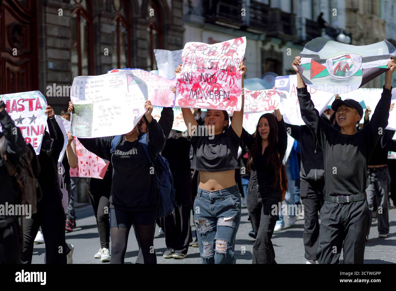 Un gruppo di studenti a Puebla marciano con segni e bandiere palestinesi, chiedendo libertà e denunciando il silenzio sul conflitto. Foto Stock